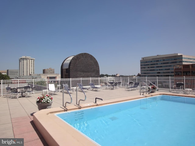 community pool with a patio and fence