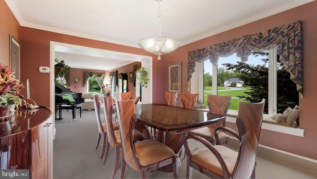 dining area featuring crown molding and light carpet