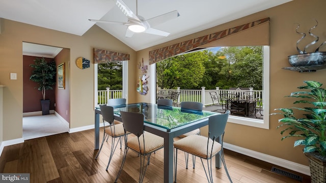 dining area with a ceiling fan, wood finished floors, baseboards, and lofted ceiling
