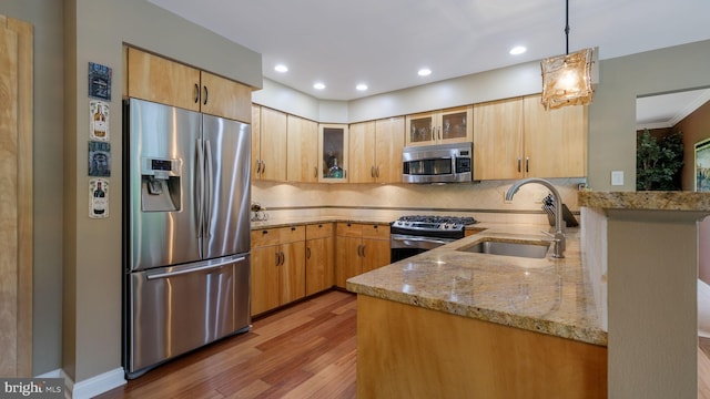 kitchen featuring appliances with stainless steel finishes, a sink, light stone counters, decorative backsplash, and recessed lighting