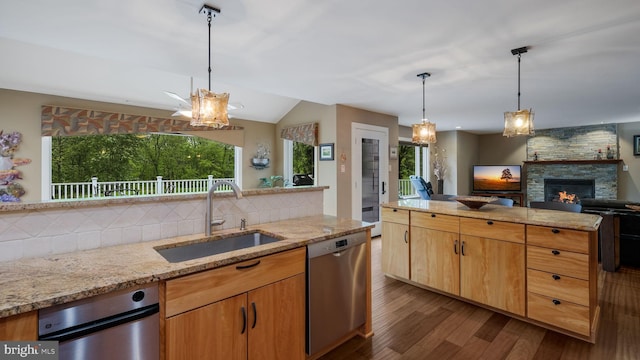 kitchen featuring a sink, dishwasher, decorative backsplash, dark wood finished floors, and a fireplace