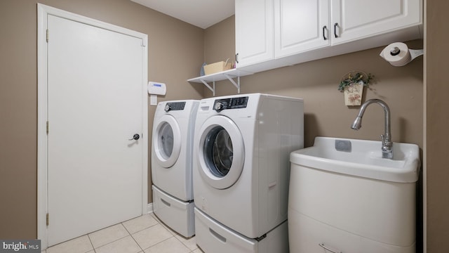 laundry area with separate washer and dryer, cabinet space, and light tile patterned floors