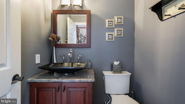 half bath featuring vanity and toilet