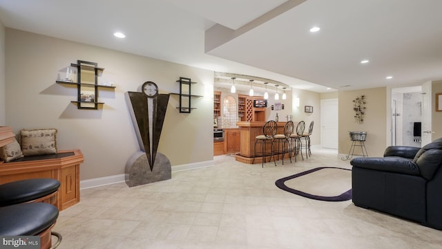 living room with wet bar, recessed lighting, and baseboards