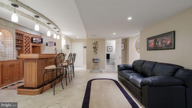 living area featuring bar with sink and recessed lighting