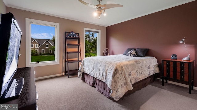 bedroom with carpet, baseboards, crown molding, and a ceiling fan