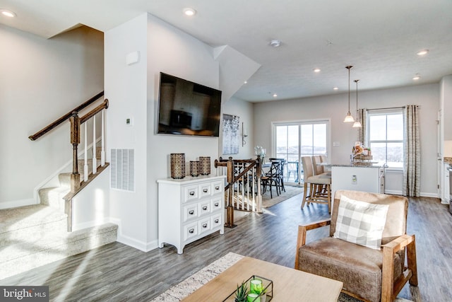 living area with dark wood-style floors, recessed lighting, baseboards, and stairs