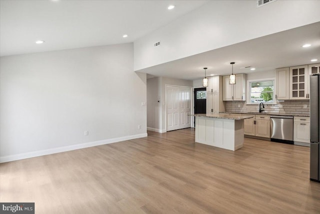 119 Oaktree Dr, Levittown, PA 19055 - kitchen with stainless steel appliances, a center island, decorative backsplash, light wood-style flooring, and glass insert cabinets