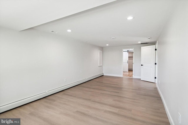 119 Oaktree Dr, Levittown, PA 19055 - spare room featuring a baseboard heating unit, recessed lighting, wood finished floors, baseboards, and a barn door