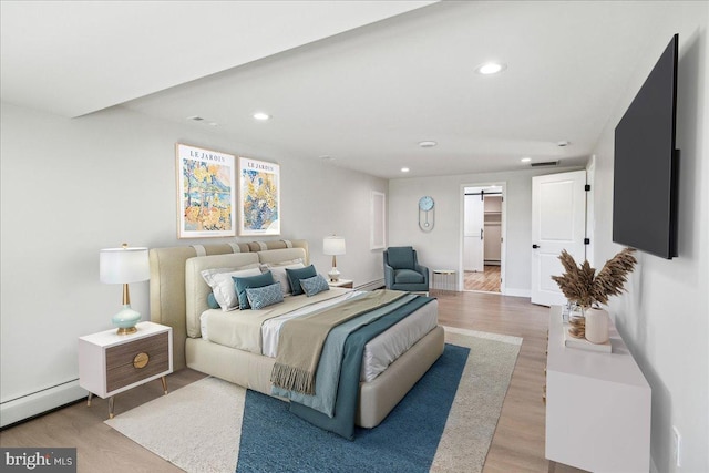 119 Oaktree Dr, Levittown, PA 19055 - bedroom with wood finished floors, a baseboard radiator, recessed lighting, a barn door, and baseboards