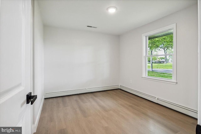 119 Oaktree Dr, Levittown, PA 19055 - spare room with wood finished floors and a baseboard radiator