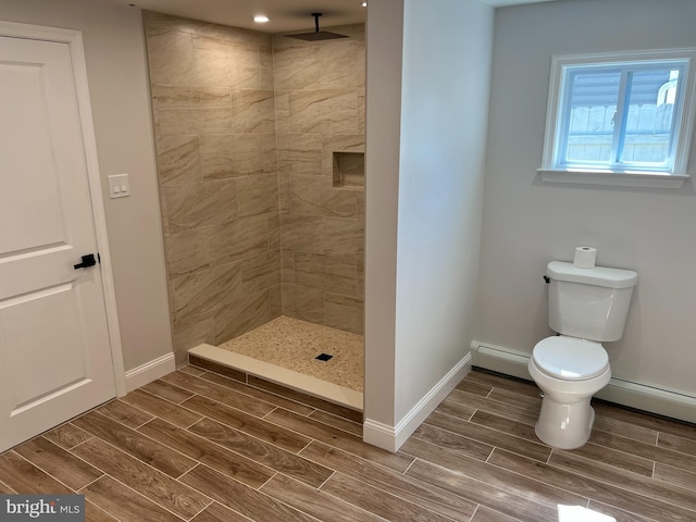 119 Oaktree Dr, Levittown, PA 19055 - bathroom with a baseboard radiator, wood tiled floors, tiled shower, and toilet