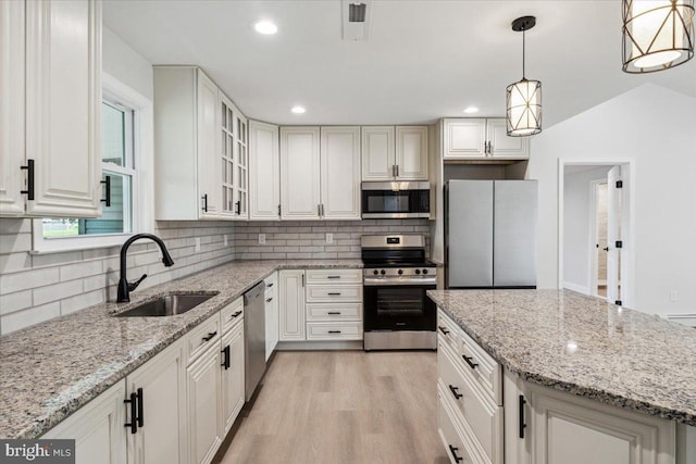 119 Oaktree Dr, Levittown, PA 19055 - kitchen with appliances with stainless steel finishes, a sink, decorative backsplash, light wood finished floors, and glass insert cabinets
