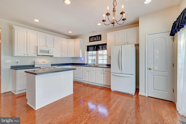 kitchen with white appliances, white cabinets, dark countertops, and recessed lighting