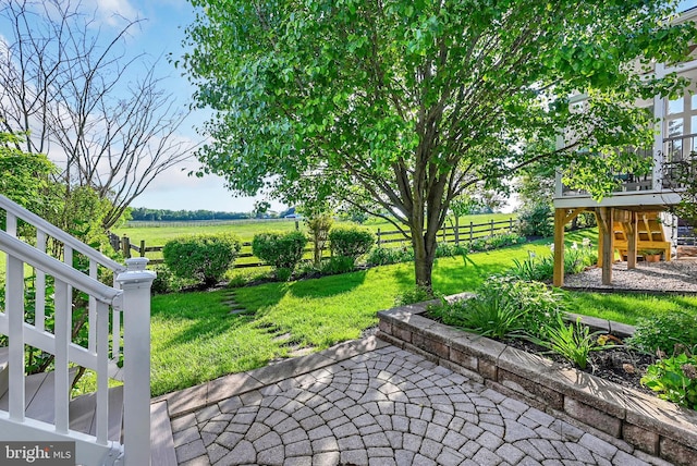 view of yard with a view of countryside, stairs, and a patio