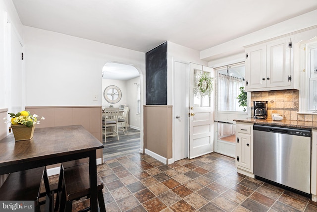 717 E Greenman Rd, Haddonfield, NJ 08033 - kitchen featuring stainless steel dishwasher, stone tile floors, arched walkways, tasteful backsplash, and white cabinetry