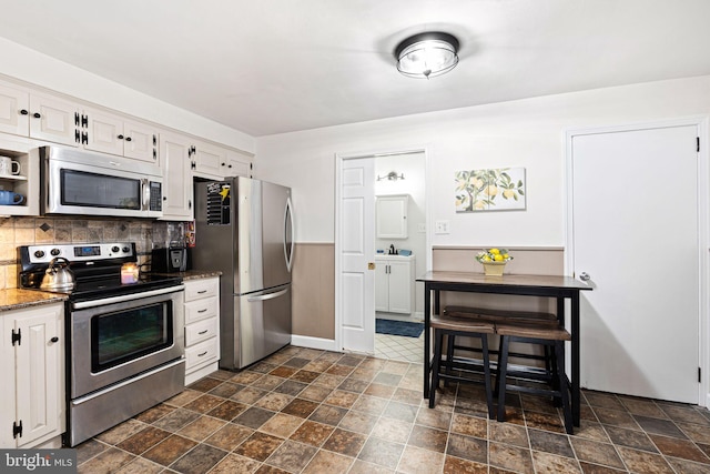 717 E Greenman Rd, Haddonfield, NJ 08033 - kitchen featuring stainless steel appliances, stone finish flooring, white cabinetry, tasteful backsplash, and dark stone counters