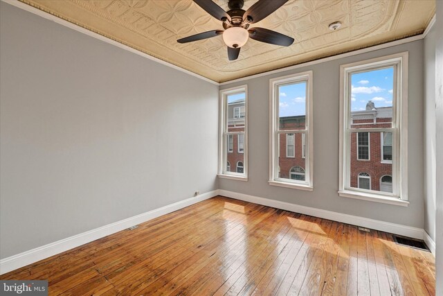 1407 Clarkson St, Baltimore, MD 21230 - empty room featuring wood-type flooring, baseboards, an ornate ceiling, ceiling fan, and crown molding