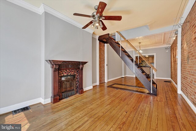 1407 Clarkson St, Baltimore, MD 21230 - workout area featuring brick wall, a fireplace, wood-type flooring, baseboards, and a ceiling fan