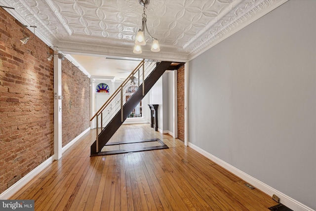 1407 Clarkson St, Baltimore, MD 21230 - corridor with baseboards, stairs, hardwood / wood-style floors, brick wall, and crown molding