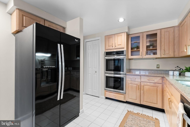 930 Astern Way Unit 502, Annapolis, MD 21401 - kitchen featuring appliances with stainless steel finishes, light brown cabinetry, glass insert cabinets, light tile patterned floors, and light stone counters