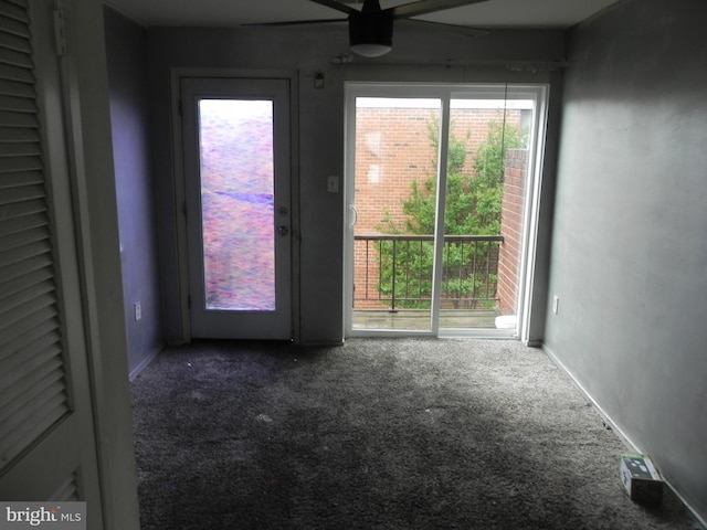 carpeted empty room featuring a ceiling fan and baseboards