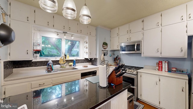 504 SE Front St, Milford, DE 19963 - kitchen featuring appliances with stainless steel finishes, decorative backsplash, a sink, and white cabinets