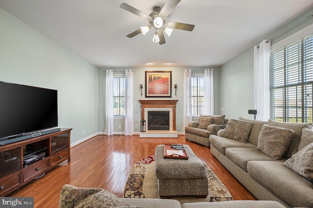 99 Topaz Ln, Camden Wyoming, DE 19934 - living room featuring ceiling fan, light wood-type flooring, a glass covered fireplace, and baseboards