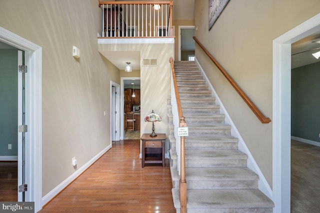 99 Topaz Ln, Camden Wyoming, DE 19934 - stairs with a high ceiling, wood finished floors, and baseboards