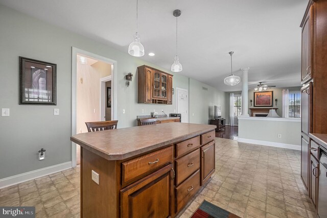 99 Topaz Ln, Camden Wyoming, DE 19934 - kitchen with a center island, baseboards, ceiling fan, hanging light fixtures, and glass insert cabinets