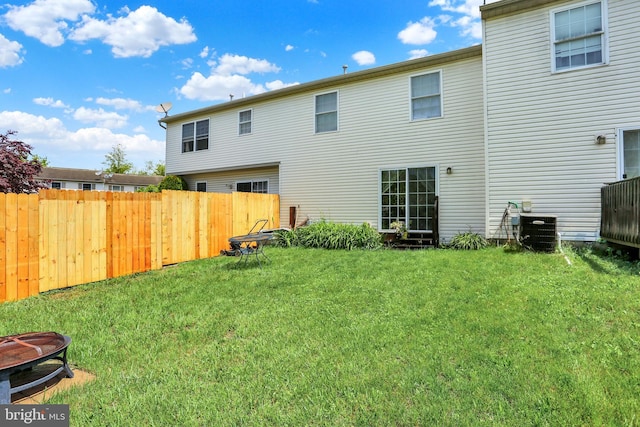 back of house featuring cooling unit and an outdoor fire pit