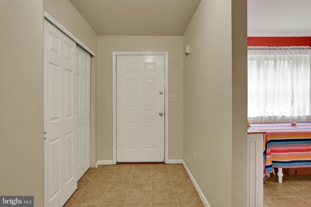 hallway with light tile patterned floors and baseboards