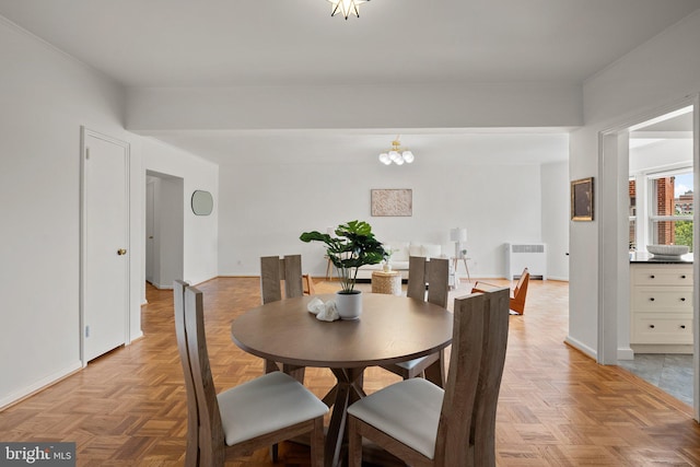 dining space with radiator, baseboards, and a chandelier