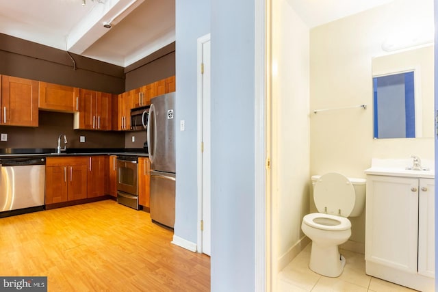 1324 Locust St Unit 1602, Philadelphia, PA 19107 - kitchen with appliances with stainless steel finishes, a sink, brown cabinetry, and dark countertops