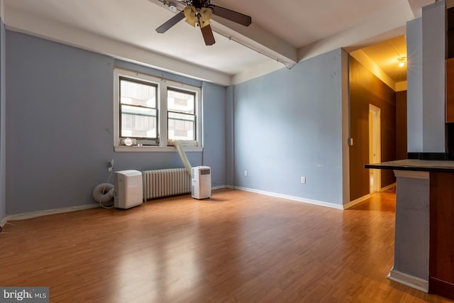 1324 Locust St Unit 1602, Philadelphia, PA 19107 - empty room featuring a ceiling fan, radiator heating unit, wood finished floors, and baseboards