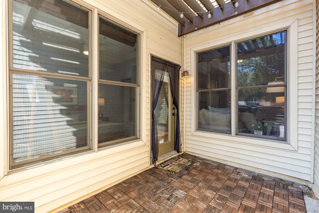 view of exterior entry with a pergola