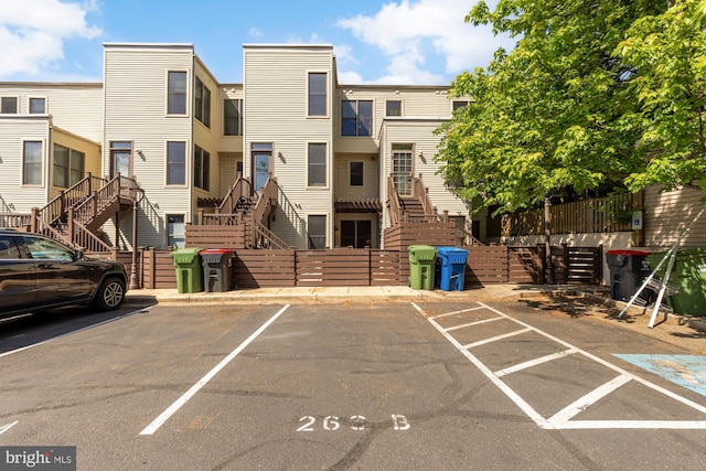 uncovered parking lot featuring stairway and fence