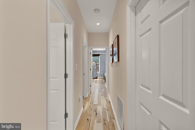 hallway featuring baseboards and light wood-type flooring
