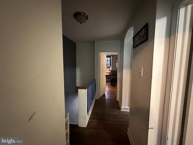 hall with dark wood-style floors and baseboards