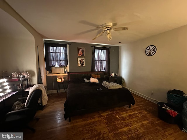 bedroom featuring wood finished floors, cooling unit, baseboards, and ceiling fan