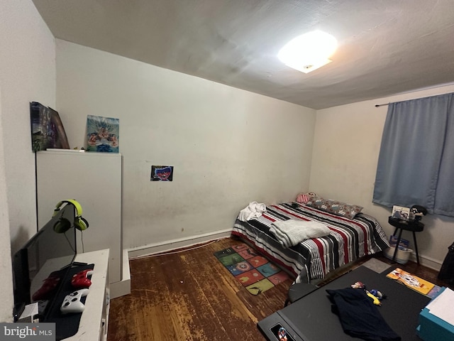bedroom featuring wood finished floors and baseboards