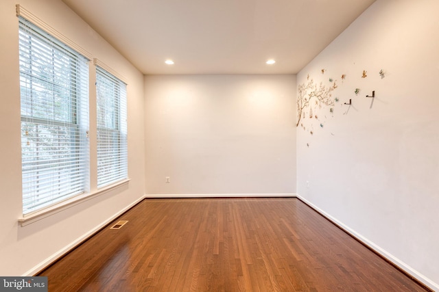 unfurnished room with wood finished floors, recessed lighting, and baseboards