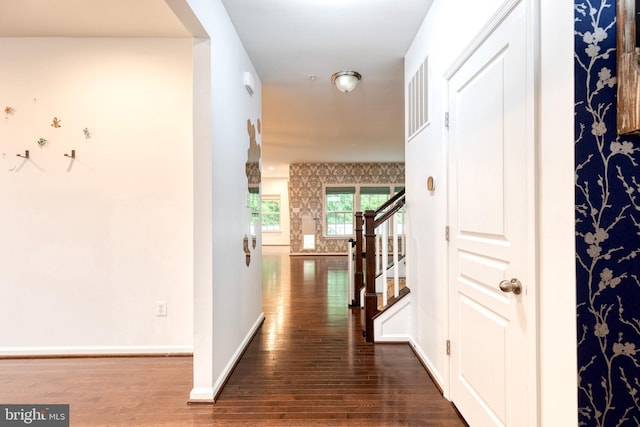 corridor with wood-type flooring, stairs, and baseboards