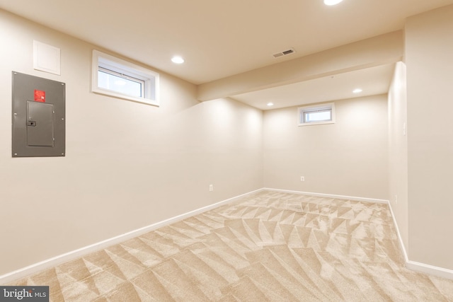 below grade area featuring electric panel, light carpet, baseboards, and recessed lighting