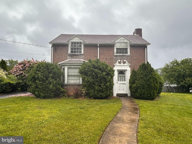 view of front facade featuring a chimney and brick siding
