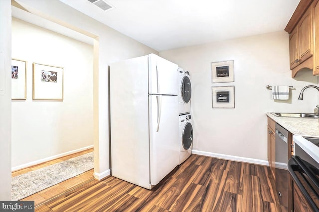 4601 N Park Ave Unit 514, Chevy Chase, MD 20815 - clothes washing area with stacked washing machine and dryer, dark wood finished floors, and baseboards
