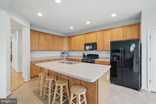13551 Elysian Dr, Leesburg, VA 20176 - kitchen with black appliances, a sink, light countertops, a center island with sink, and recessed lighting