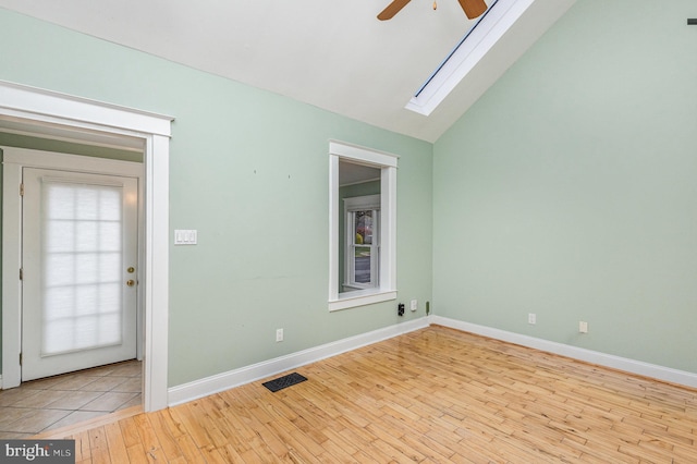 1616 S Oakland St, Arlington, VA 22204 - unfurnished room with ceiling fan, wood-type flooring, a skylight, vaulted ceiling, and baseboards
