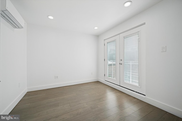 spare room with a wall mounted AC, french doors, baseboards, and recessed lighting