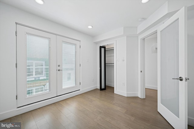 unfurnished bedroom featuring french doors, access to exterior, wood finished floors, recessed lighting, and baseboards